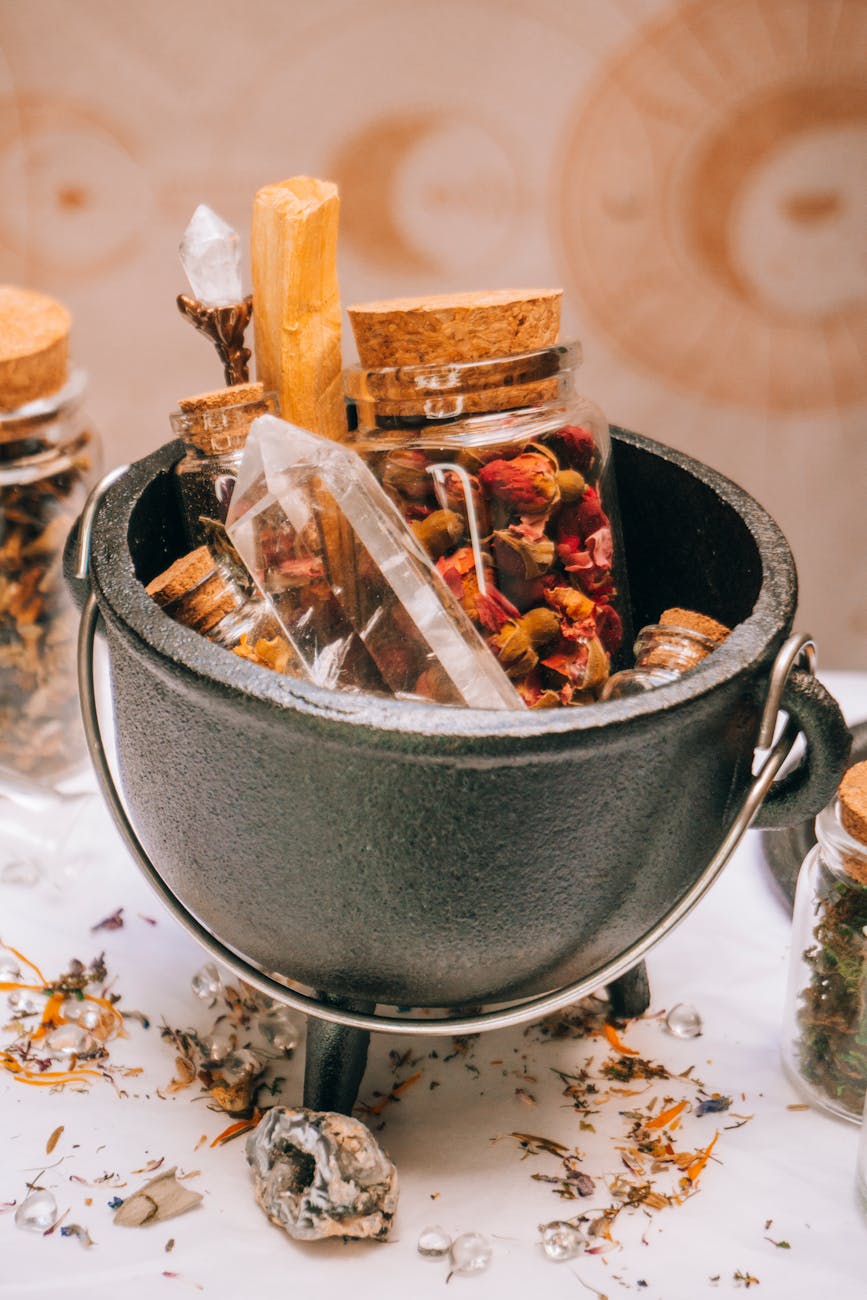 cauldron with quartz and dry spices in glass jars